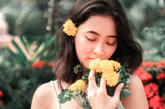woman smelling spring flowers that inspire spring perfumes