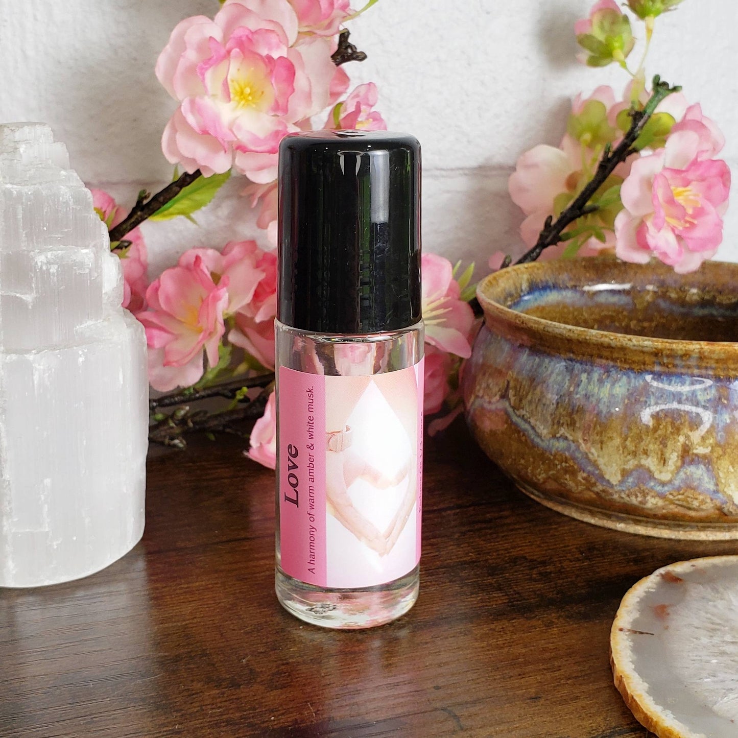 love perfume oil bottle on a table with flowers