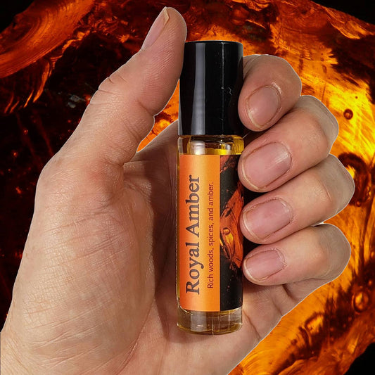 Royal Amber Perfume Oil bottle in hand over background
