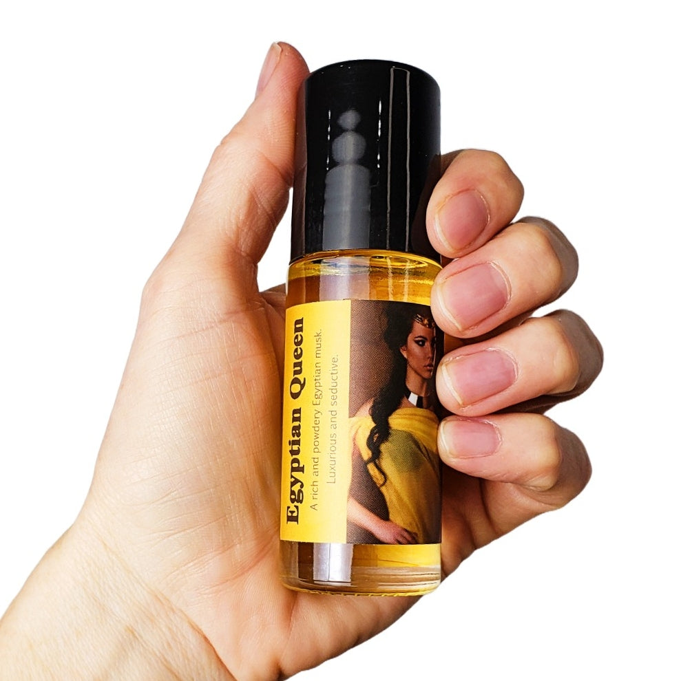 large 1 ounce bottle of egyptian queen perfume oil held in hand for scale