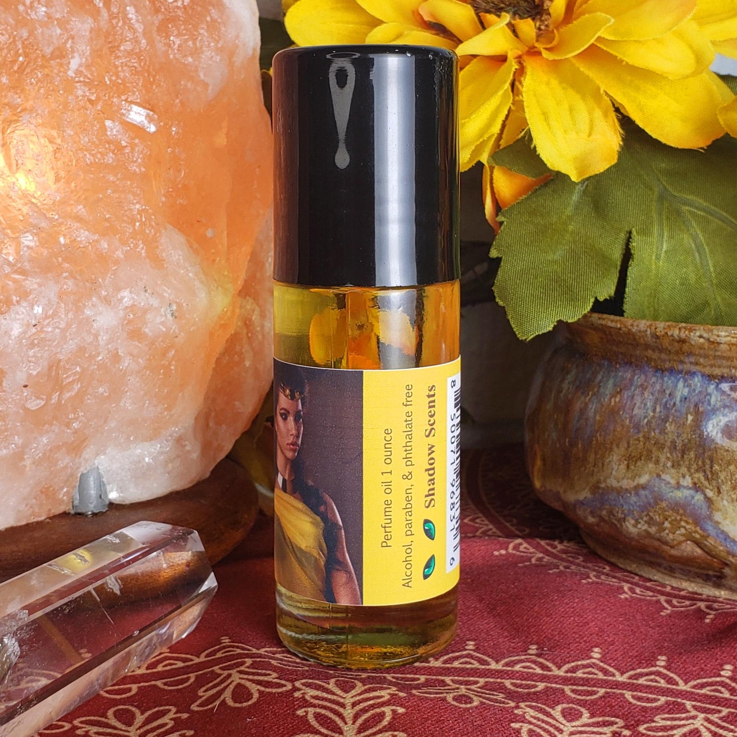 A 1 oz bottle of Shadow Scents egyptian queen roll-on perfume oil with a black cap, showing the barcode and product specs with logo on the label