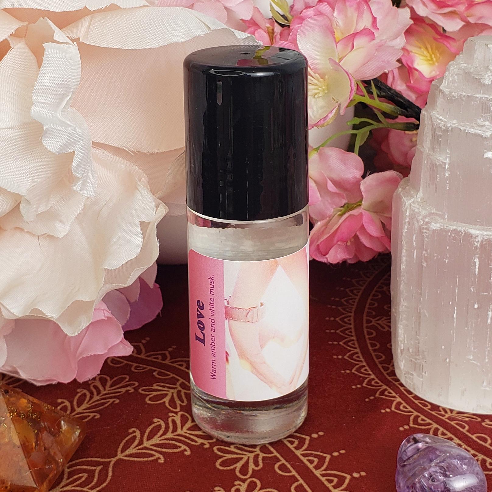 A bottle of Love perfume oil, showing the black cap covering the rollerball.