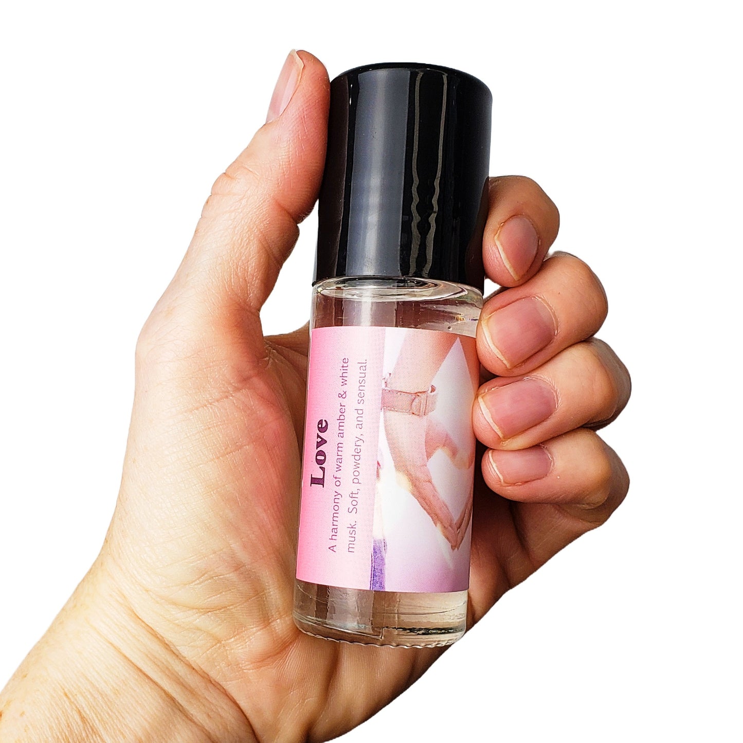 large one ounce love perfume oil held in hand
