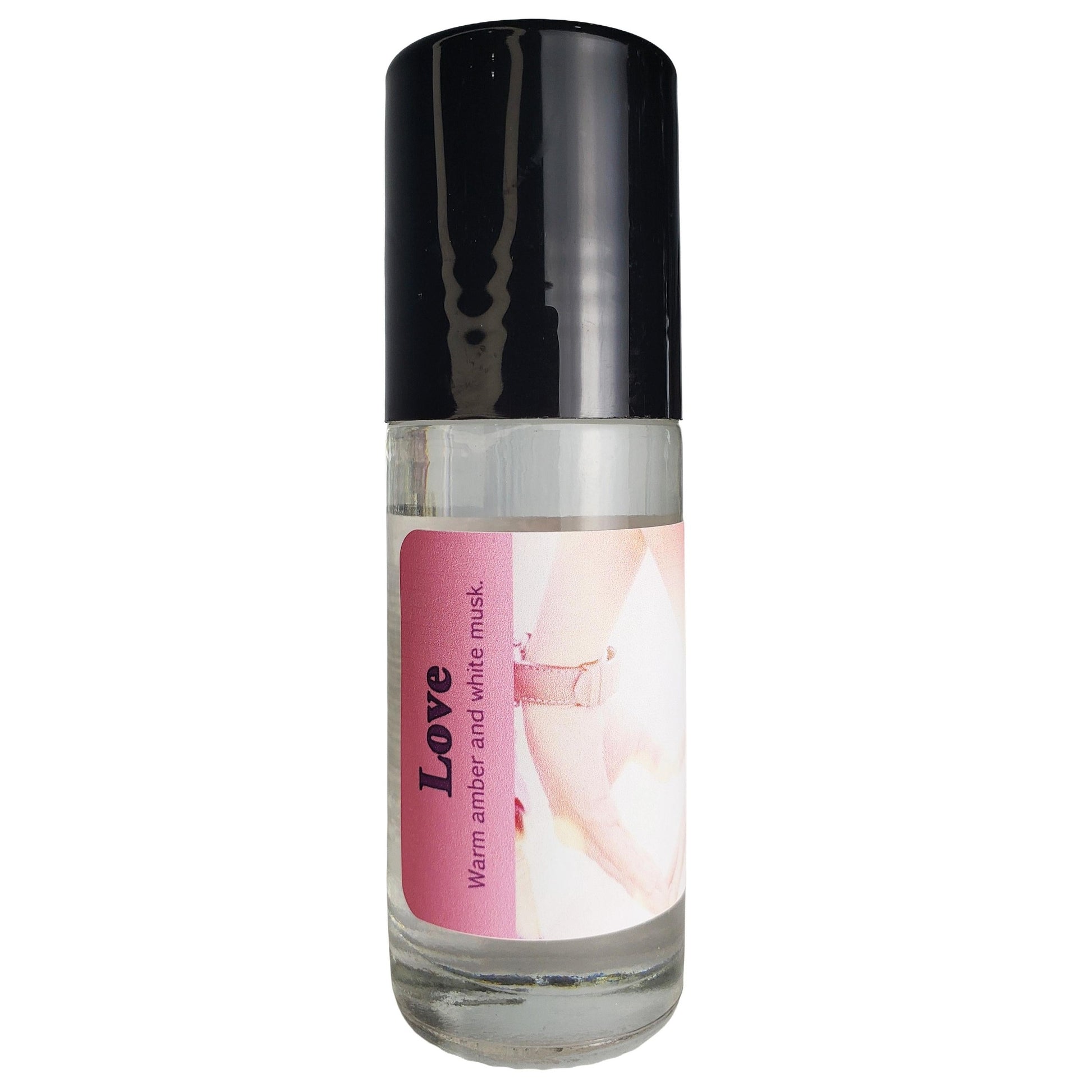 A clear cylindrical bottle with a black cap and a pink label for Love perfume oil, 'Warm amber and white mask', shown on a plain white background.